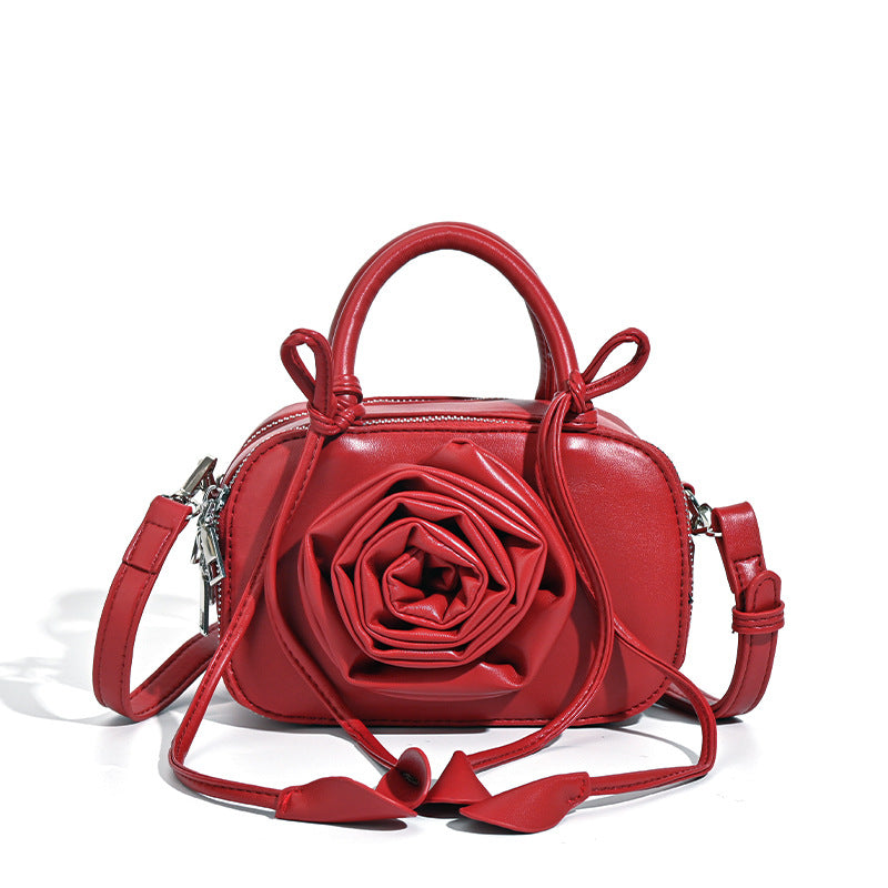 compact barrel bag with 3D rose appliqué, dual zip top, knotted handle, and adjustable crossbody strap, detail view 5