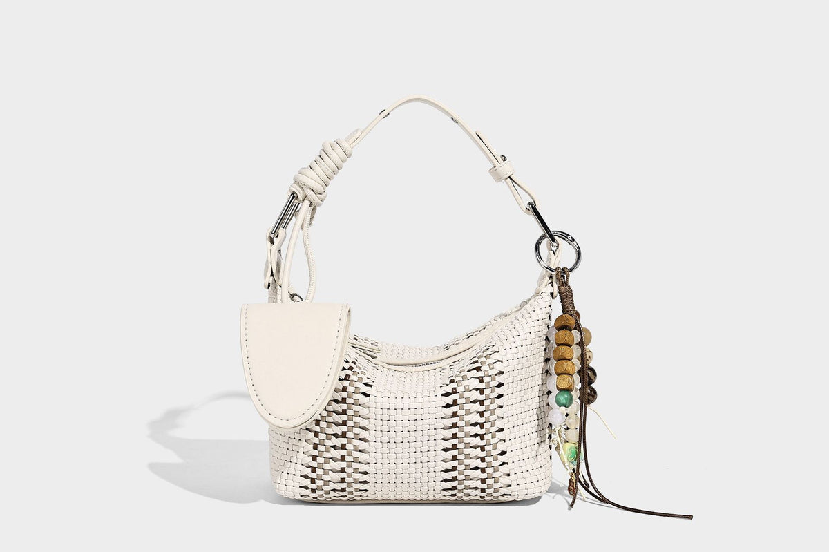Small woven crescent shoulder bag with leather-look trim, zip closure, silver-tone ring hardware, and beaded tassel charm