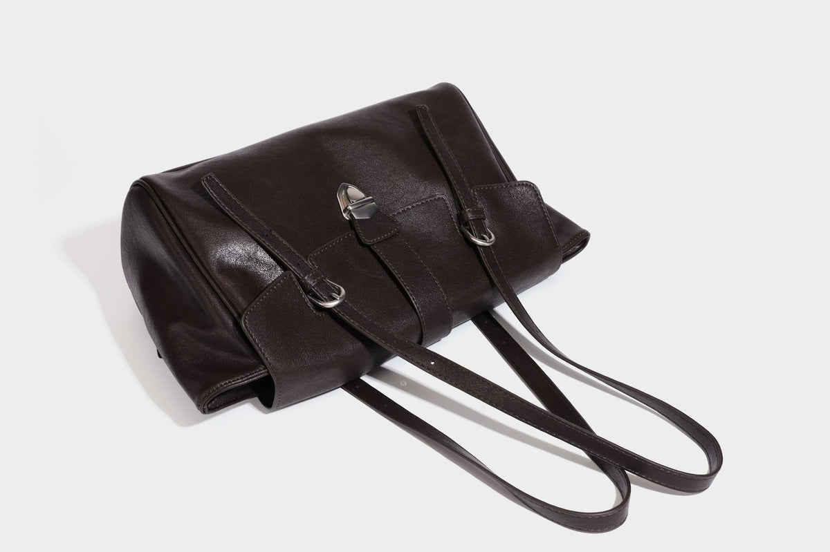 Large structured vintage-style tote bag with flap-front turn-lock closure, twin buckle straps, and double shoulder handles