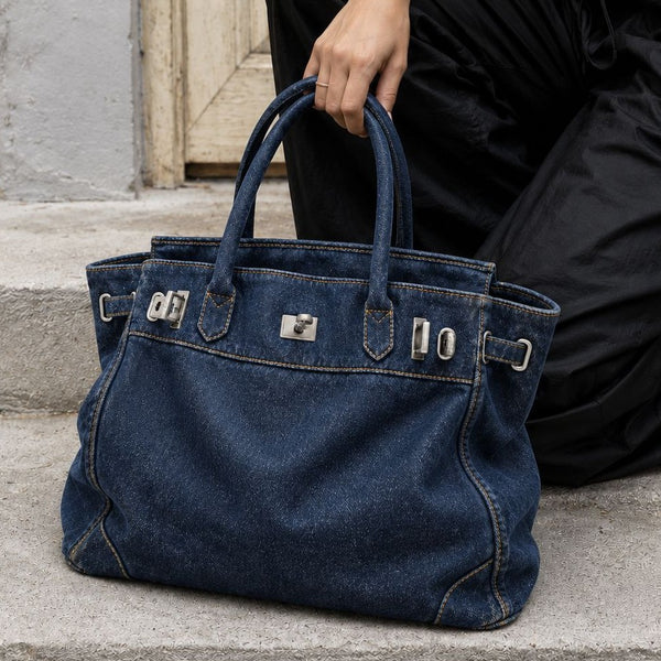 Lässig geschnittene Tote-Bag aus Denim mit silberfarbenem Drehverschluss und Schnallendetails sowie zwei gerollten Henkeln, Detailansicht 3