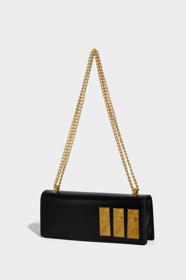 Structured rectangular crossbody bag with glossy finish, three vertical gold-tone embossed plaques, and gold chain strap