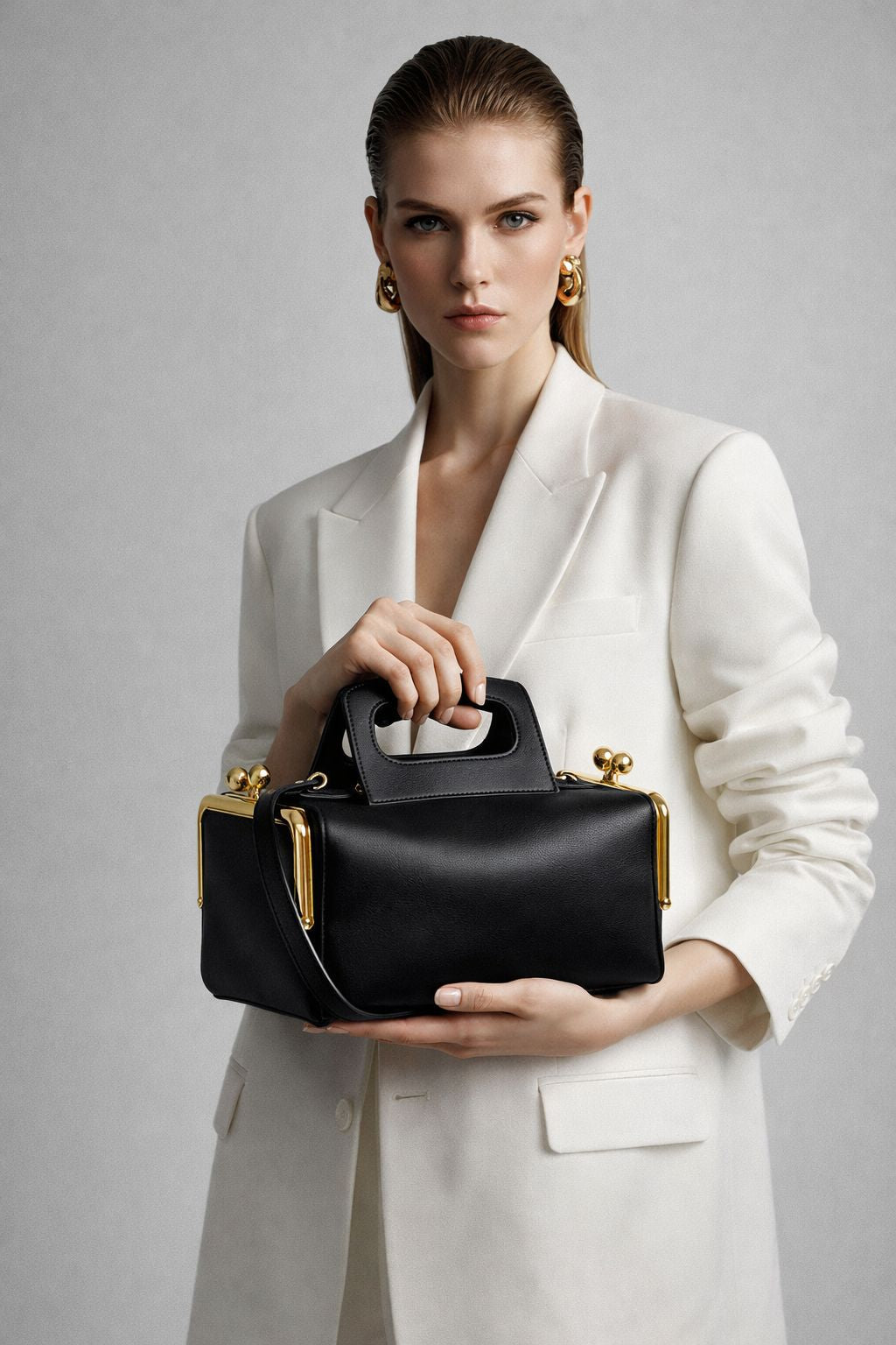 Kompakte dunkelbraune Henkeltasche in Lederoptik mit goldfarbenem Rahmenbeschlag und abnehmbarem, verstellbarem Crossbody-Riemen