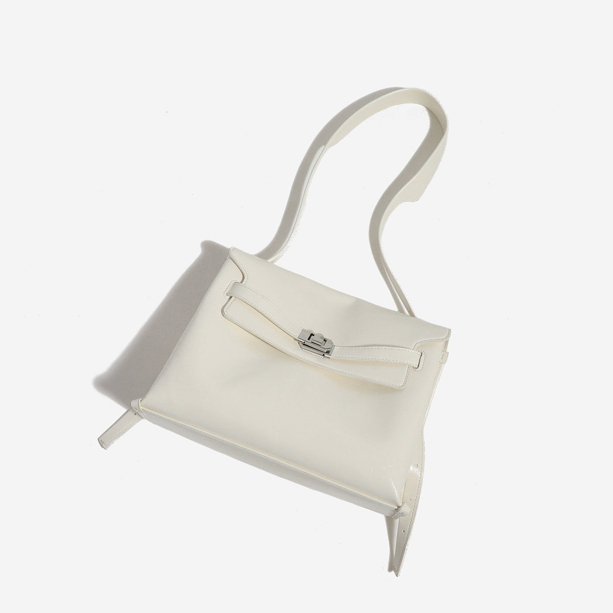 Structured rectangular flap shoulder bag in glossy leather-look finish with silver-tone turn-lock closure and adjustable