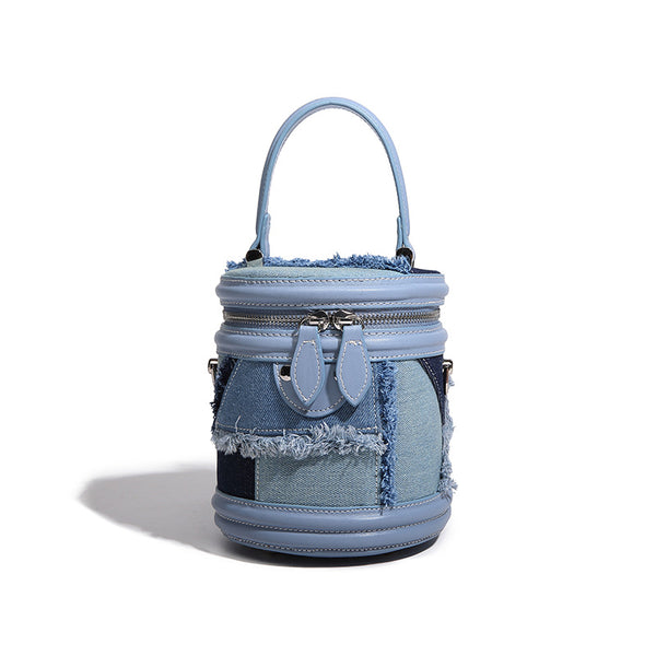 Mini cylindrical barrel bucket bag in denim patchwork with frayed edges, smooth leather-look trim, zip-around top closure