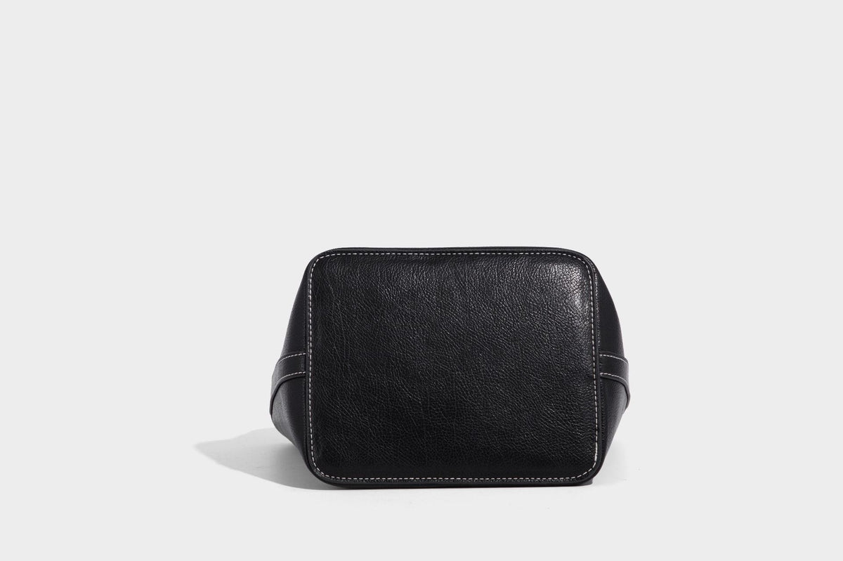 Compact structured bucket tote bag with pebbled textured finish, dual top handles, silver-tone lock hardware, and detachable