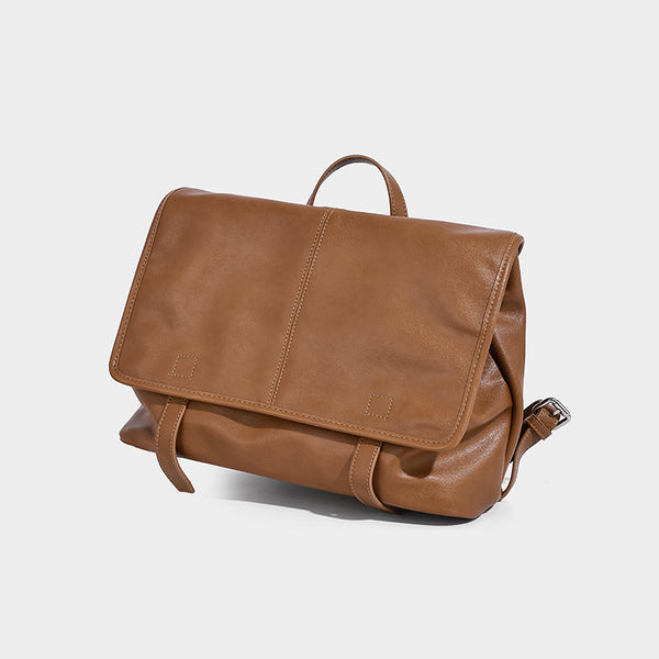 Structured tan leather-look flap backpack handbag with top handle, silver buckle hardware, and fold-over front closure