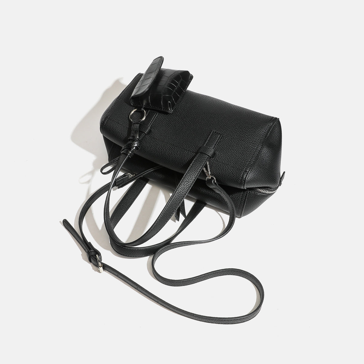 Structured pebbled leather-look top-zip barrel bag with dual handles, detachable shoulder strap, and attached croc-pattern