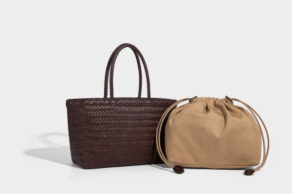 Structured chevron woven leather-look tote bag with braided top handles, gold feather charm, and adjustable shoulder strap