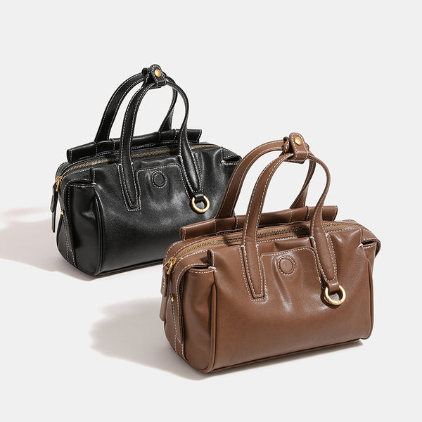 Compact structured satchel bag with dual top handles, gold-tone O-ring hardware, contrast topstitching, and detachable, front