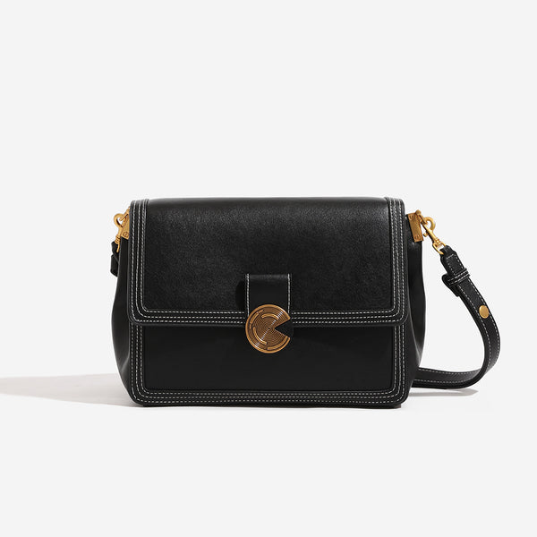 Structured flap shoulder bag with gold-tone circular turn-lock closure, white contrast stitching, and adjustable strap