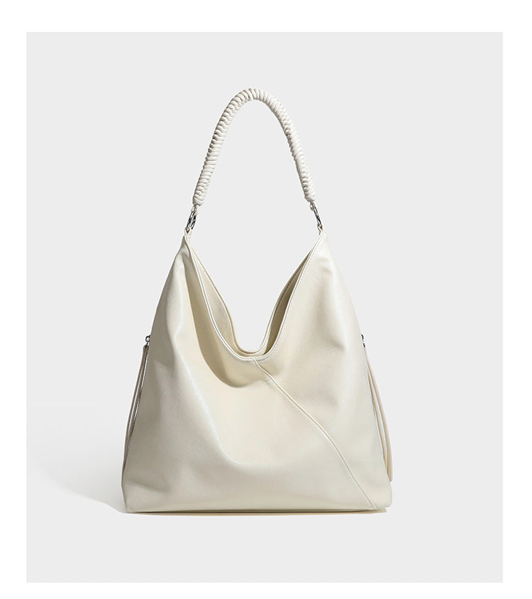 Large slouchy hobo shoulder bag with braided top handle, smooth glossy leather-look finish, and silver-tone ring hardware