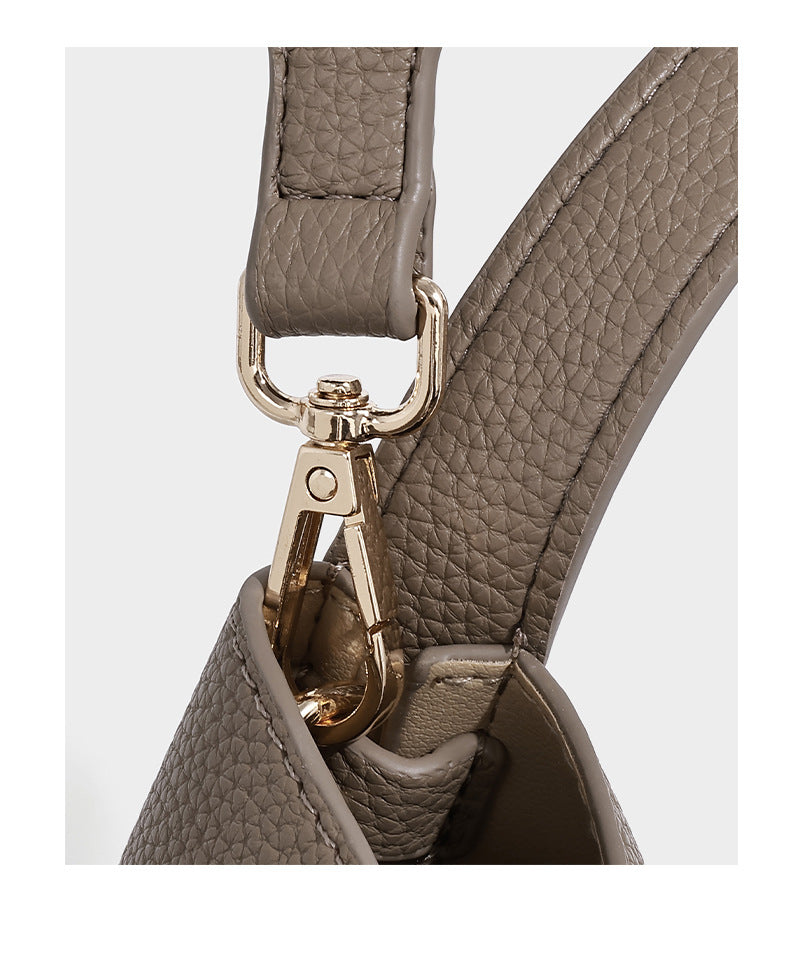 Structured trapezoid tote bag in taupe pebbled leather-look finish with gold-tone turn-lock hardware, dual top handles, and