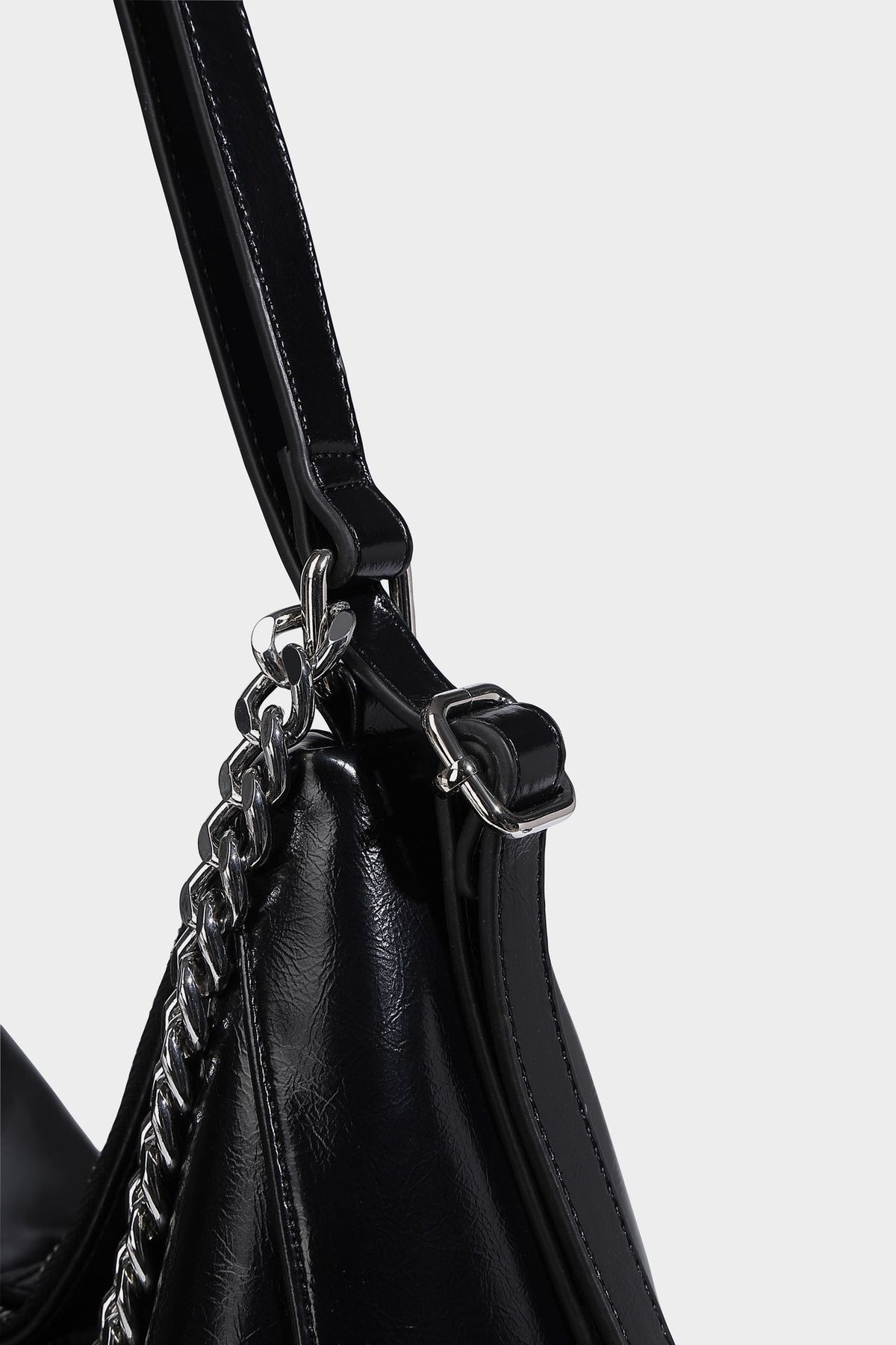 Glänzend schwarze Hobo-Shopper-Tasche mit silberfarbenem Kettenakzent, Reißverschluss oben und langen Schulterriemen, Detailansicht 21