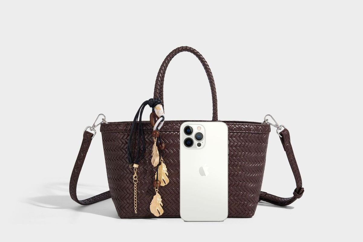 Structured chevron woven leather-look tote bag with braided top handles, gold feather charm, and adjustable shoulder strap
