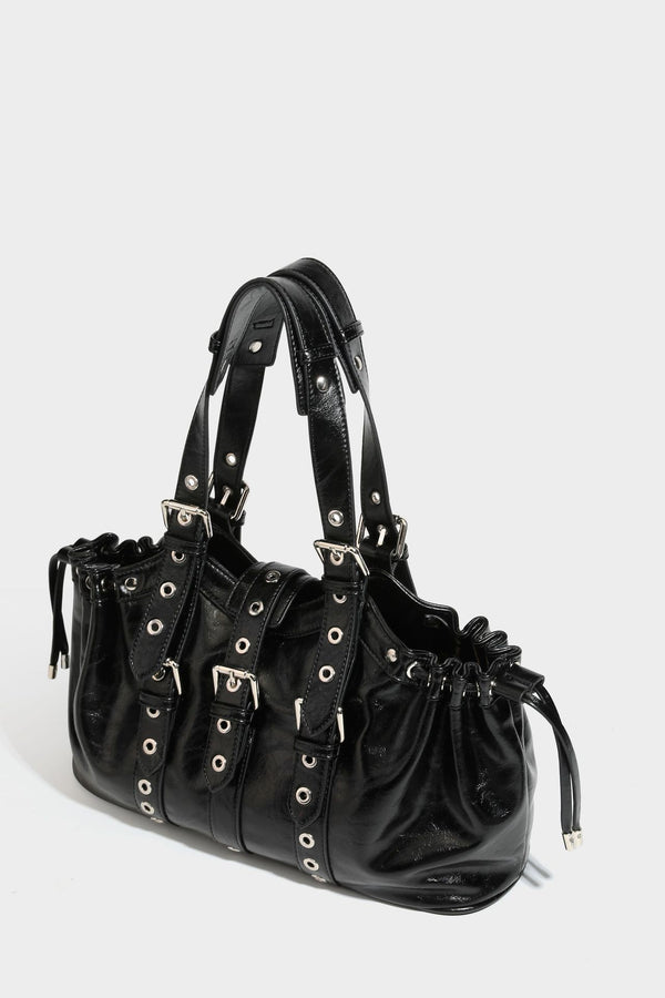 Large black glossy leather-look tote bag with silver buckle straps, eyelet grommet panels, drawstring side gathers, and
