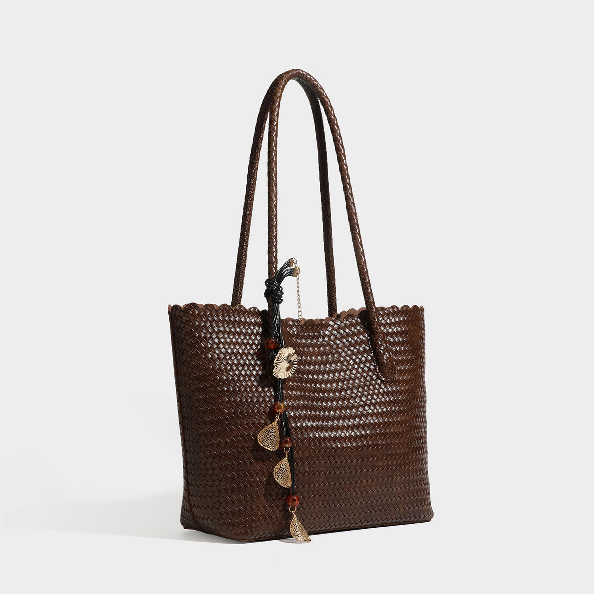 Large open-top woven leather-look tote bag in dark brown with scalloped edge, braided double shoulder straps, and decorative