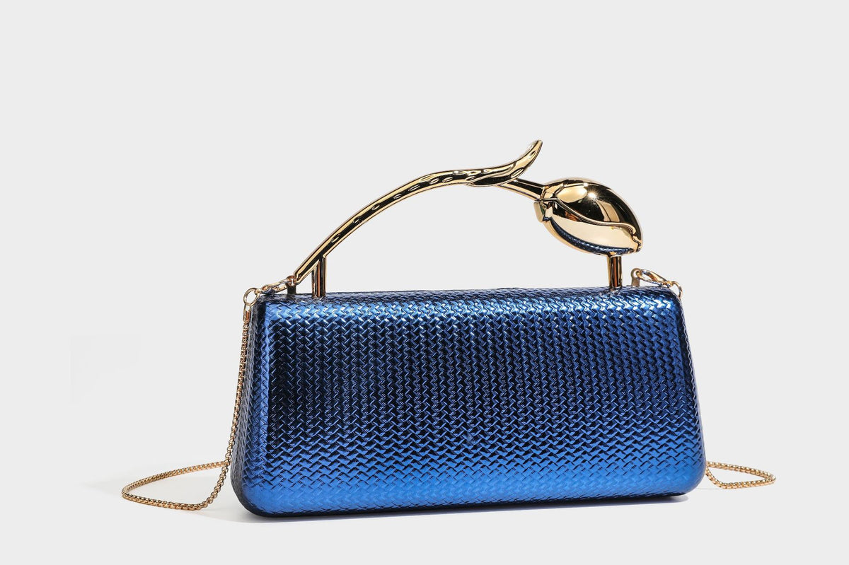 Structured rectangular metallic woven clutch bag with sculptural gold-tone leaf top handle and detachable chain strap, detail