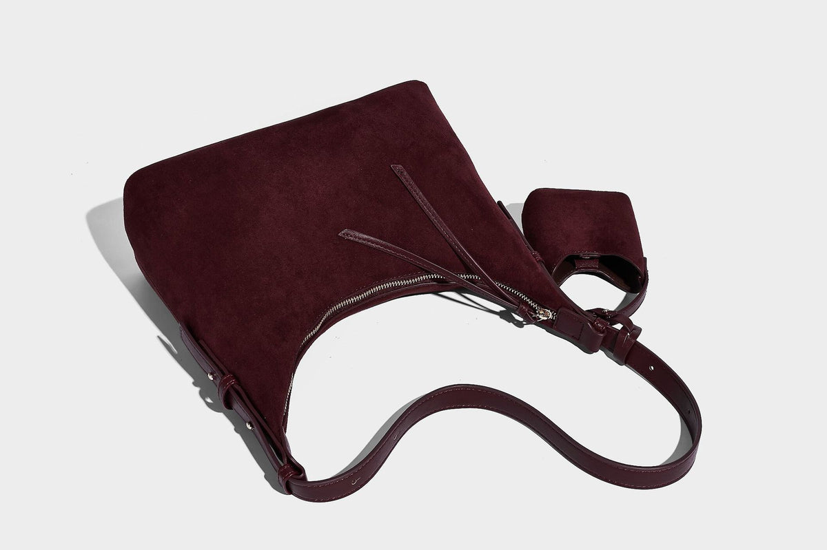 Dark brown suede-look hobo shoulder bag with top zip closure, adjustable strap, and small detachable mini pouch, detail view