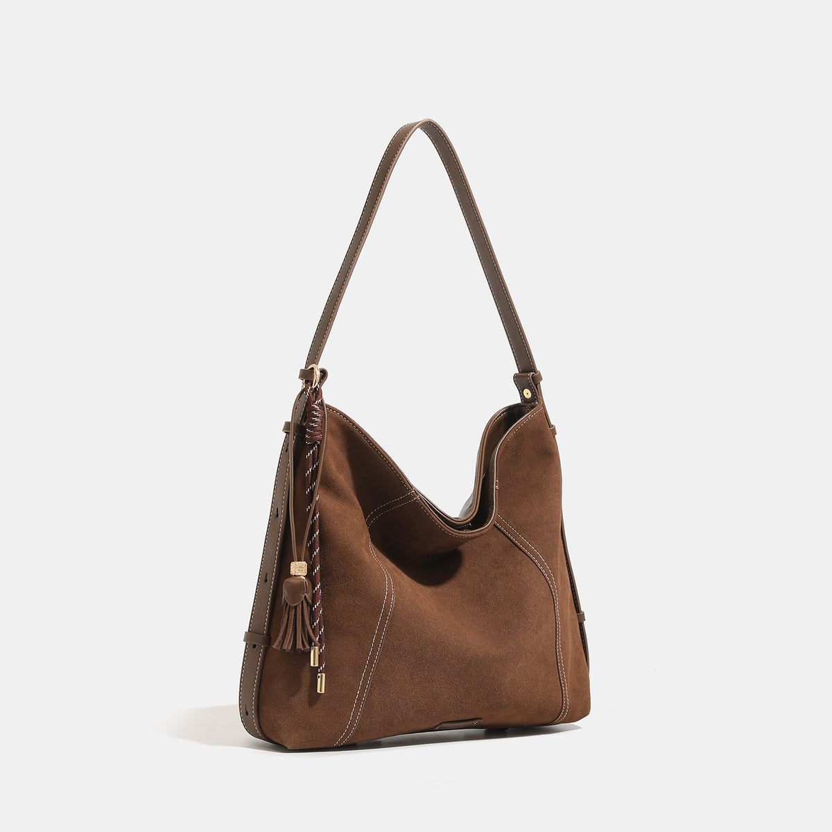 Slouchy suede-finish hobo shoulder bag in warm mocha brown with contrast stitching, braided tassel side accent, and, detail
