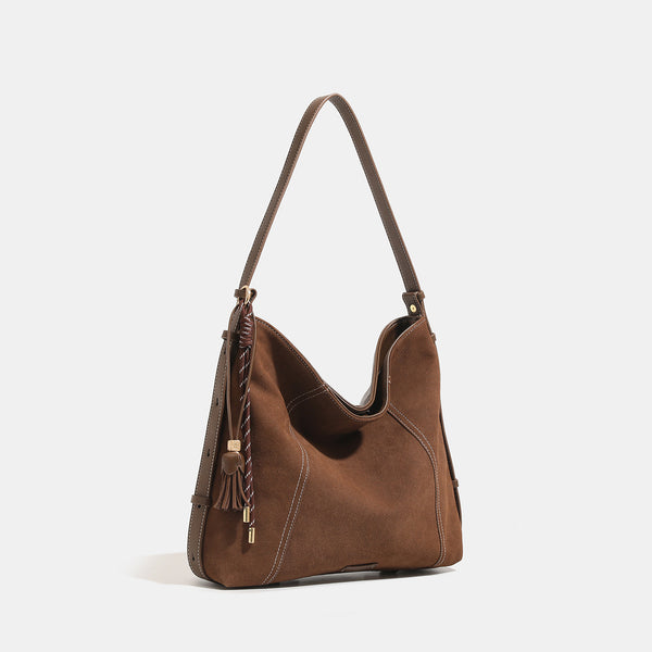 Slouchy suede-finish hobo shoulder bag in warm mocha brown with contrast stitching, braided tassel side accent, and, detail