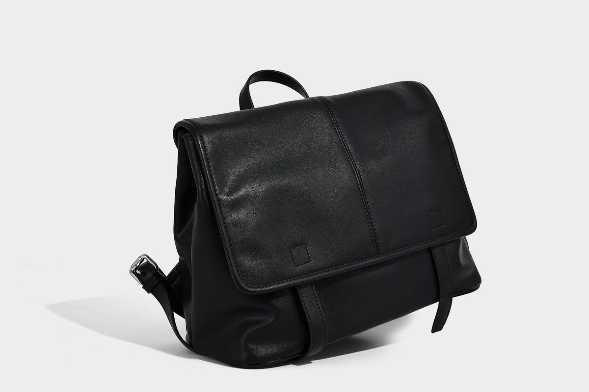 Structured tan leather-look flap backpack handbag with top handle, silver buckle hardware, and fold-over front closure
