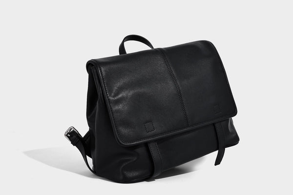 Structured tan leather-look flap backpack handbag with top handle, silver buckle hardware, and fold-over front closure