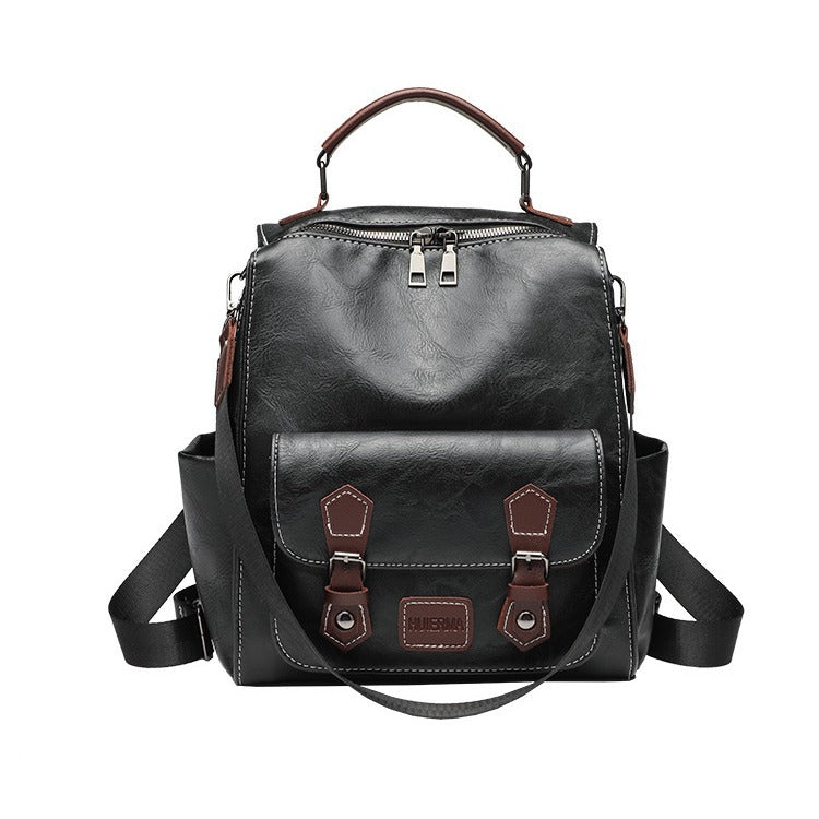 Structured black leather-look convertible backpack handbag with brown contrast trim, buckle front pocket, double-zip top