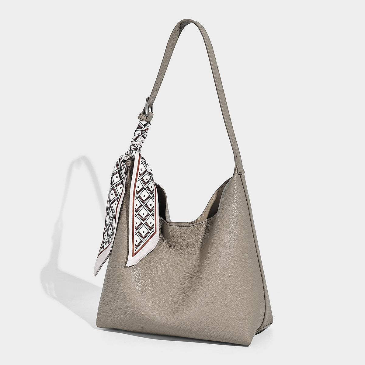 Soft slouchy hobo shoulder bag in pebbled matte finish with slim strap, silver-tone ring hardware, and knotted printed scarf