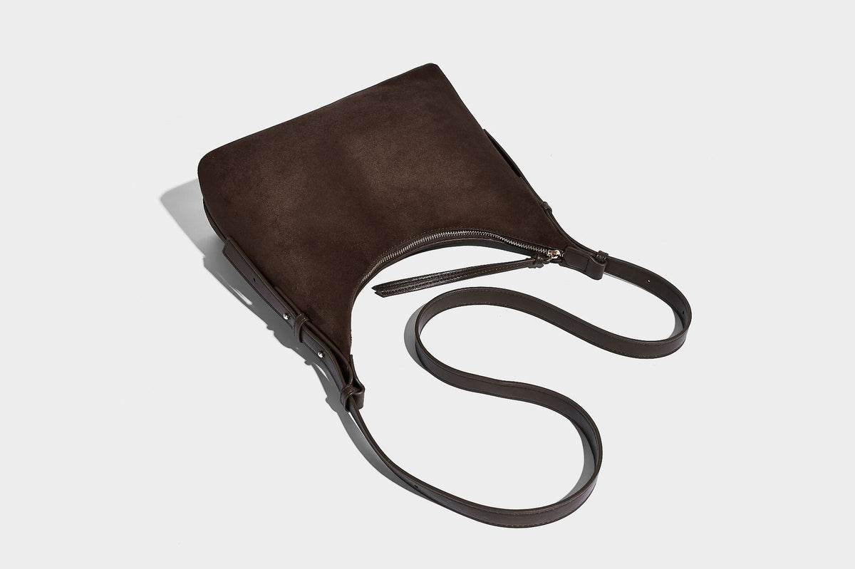 Dark brown suede-look hobo shoulder bag with top zip closure, adjustable strap, and small detachable mini pouch, detail view