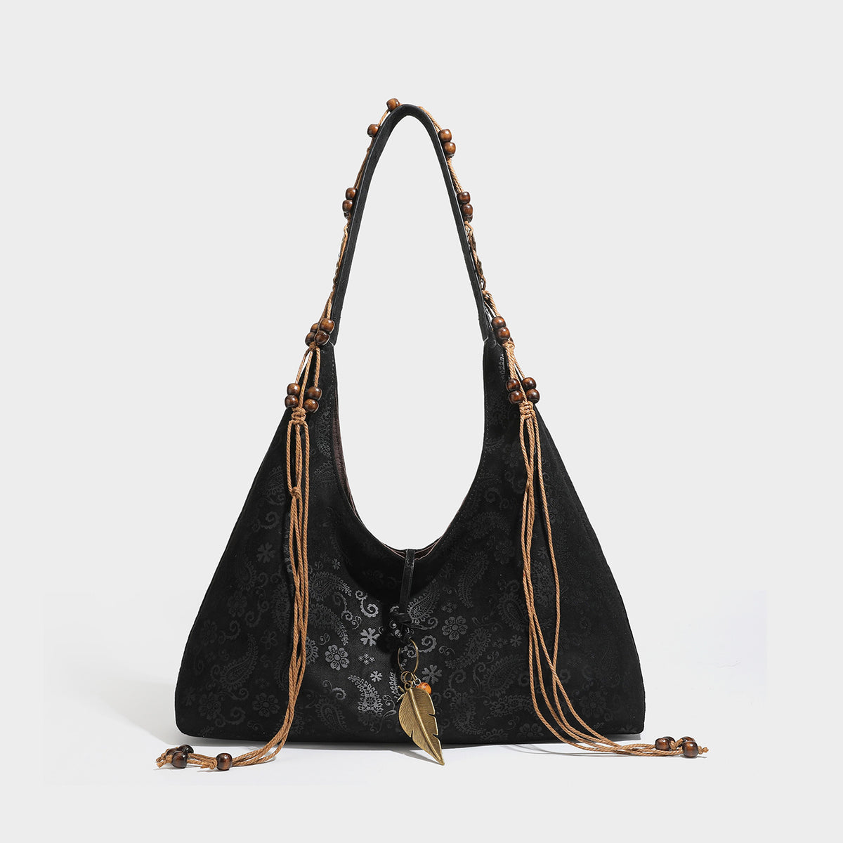 Slouchy boho hobo shoulder bag in embossed brown suede-look finish with beaded strap, cord tassels, and brass-tone leaf