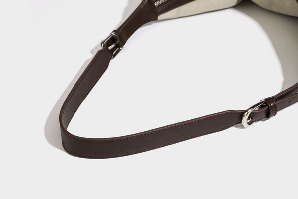Lässige Hobo-Schultertasche aus haferfarbenem Canvas mit dunkelbraunen Besätzen in Lederoptik, silberfarbenem Reißverschluss und langem, verstellbarem