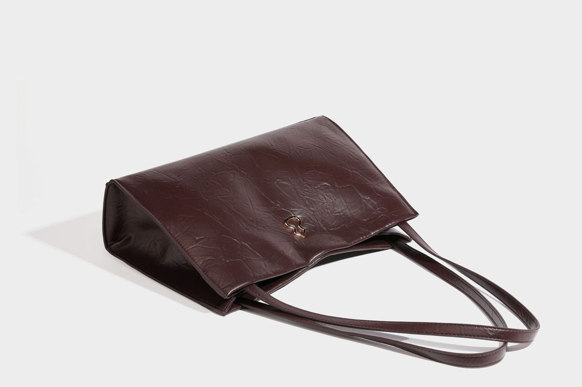 Strukturierte rechteckige Tote-Schultertasche aus glänzender, geknitterter Lederoptik mit langen Doppelträgern und Emblem in Goldoptik