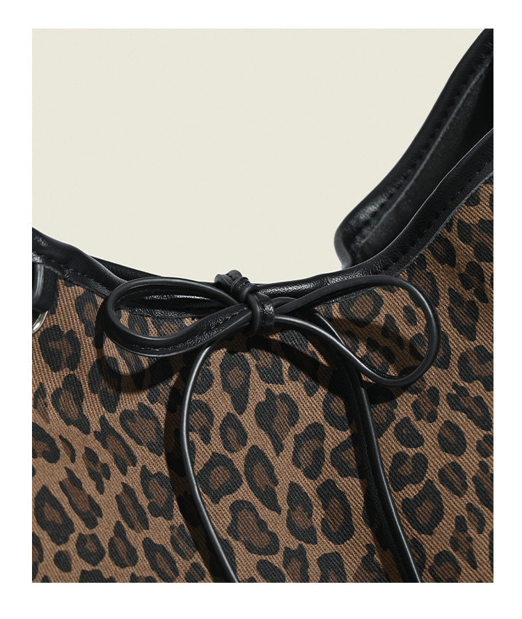 Lässig fallende Hobo-Tasche mit Leopardenmuster in Braun und Schwarz, Kordelzugverschluss mit Schleife, Besatz in schwarzer Lederoptik und Nieten in Silberoptik