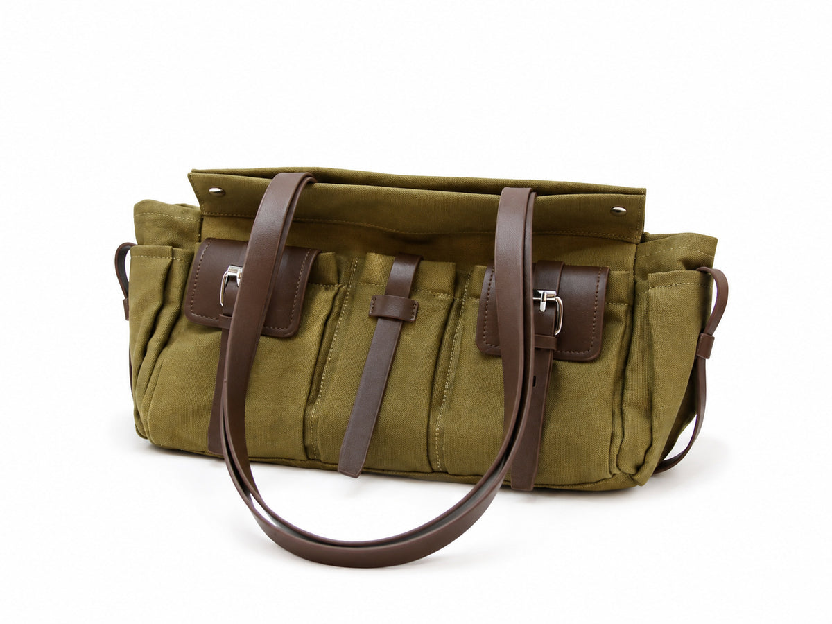 Large olive canvas shoulder tote bag with multiple front buckle-strap pockets and dark brown leather-look trim, detail view