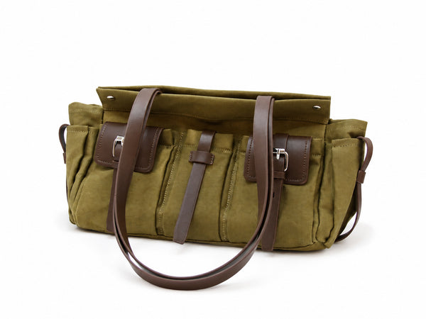 Large olive canvas shoulder tote bag with multiple front buckle-strap pockets and dark brown leather-look trim, detail view