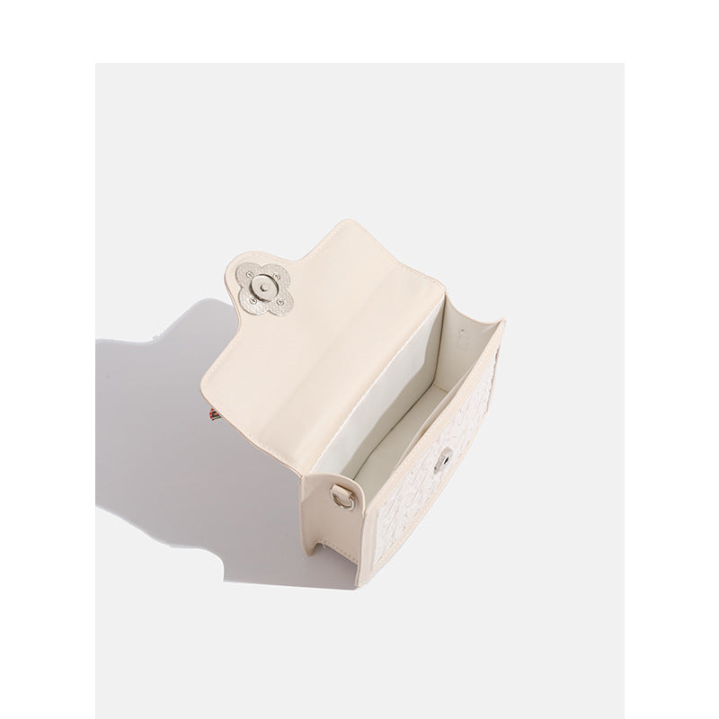 Ivory structured mini crossbody bag with crinkled leather-look finish, silk scarf top handle, silver four-petal flower clasp
