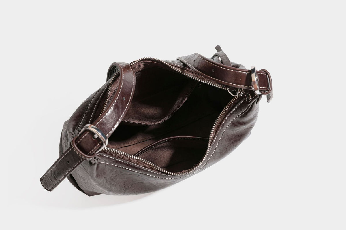 Slouchy hobo shoulder bag in glossy crinkled leather-look finish with zip-top closure and silver-tone ring hardware, detail
