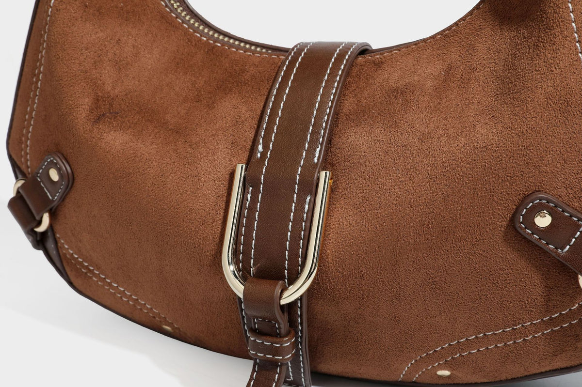 Halbmondförmige Schultertasche in camelbrauner Wildlederoptik mit weißen Kontrastnähten, goldfarbenen Beschlägen und