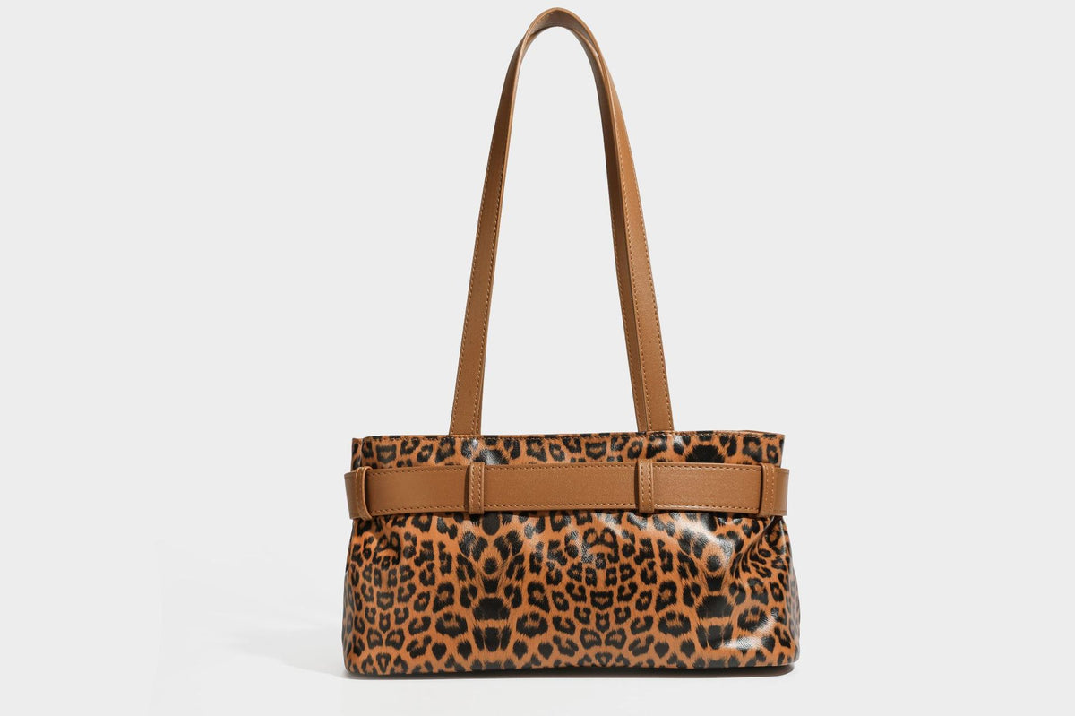 Strukturierte Schultertasche mit Leopardenmuster, Gürtelverschluss-Detail, zwei langen Riemen und silberfarbenen Metallbeschlägen, Detailansicht