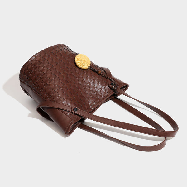 Brown embossed geometric woven leather-look bucket tote bag with dual shoulder straps, side snap hardware, and a round