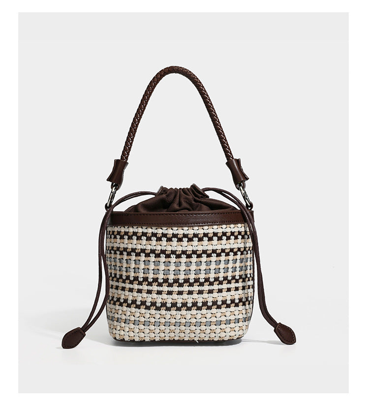 Small structured woven checker bucket bag with braided top handle, drawstring closure, and silver-tone hardware in black