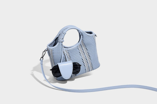 Geflochtene Bucket-Tasche in Pastellblau mit geflochtenen Henkeln, vorderem Einsteckfach, Perlenanhänger und abnehmbarem Schulterriemen