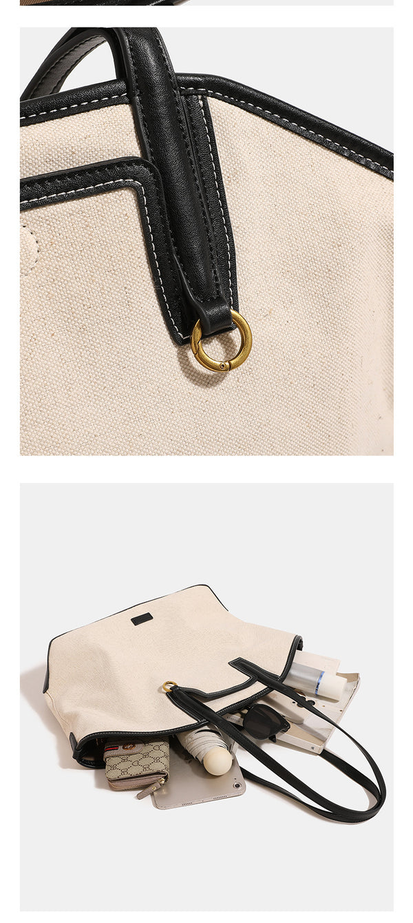 Cremefarbener Trapez-Shopper aus Canvas mit Besätzen in schwarzer Lederoptik, zwei Schulterriemen und goldfarbenen Ringbeschlägen, Detailansicht