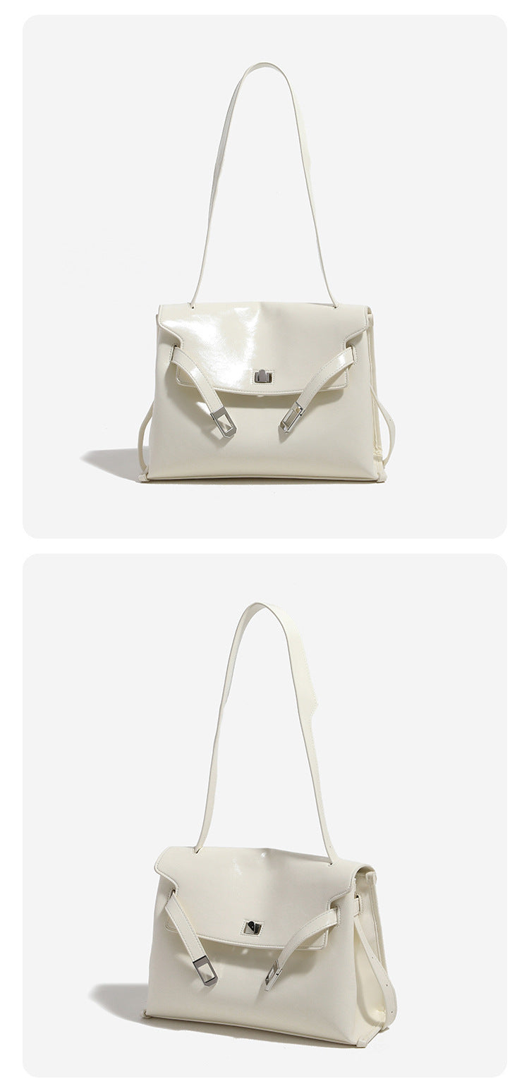 Structured rectangular flap shoulder bag in glossy leather-look finish with silver-tone turn-lock closure and adjustable