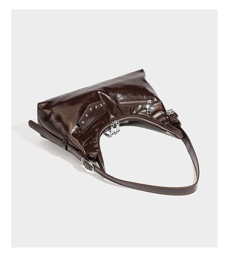 Glossy dark brown hobo shoulder bag with slim strap, front zip pocket, stud detail, and detachable leopard-print heart charm