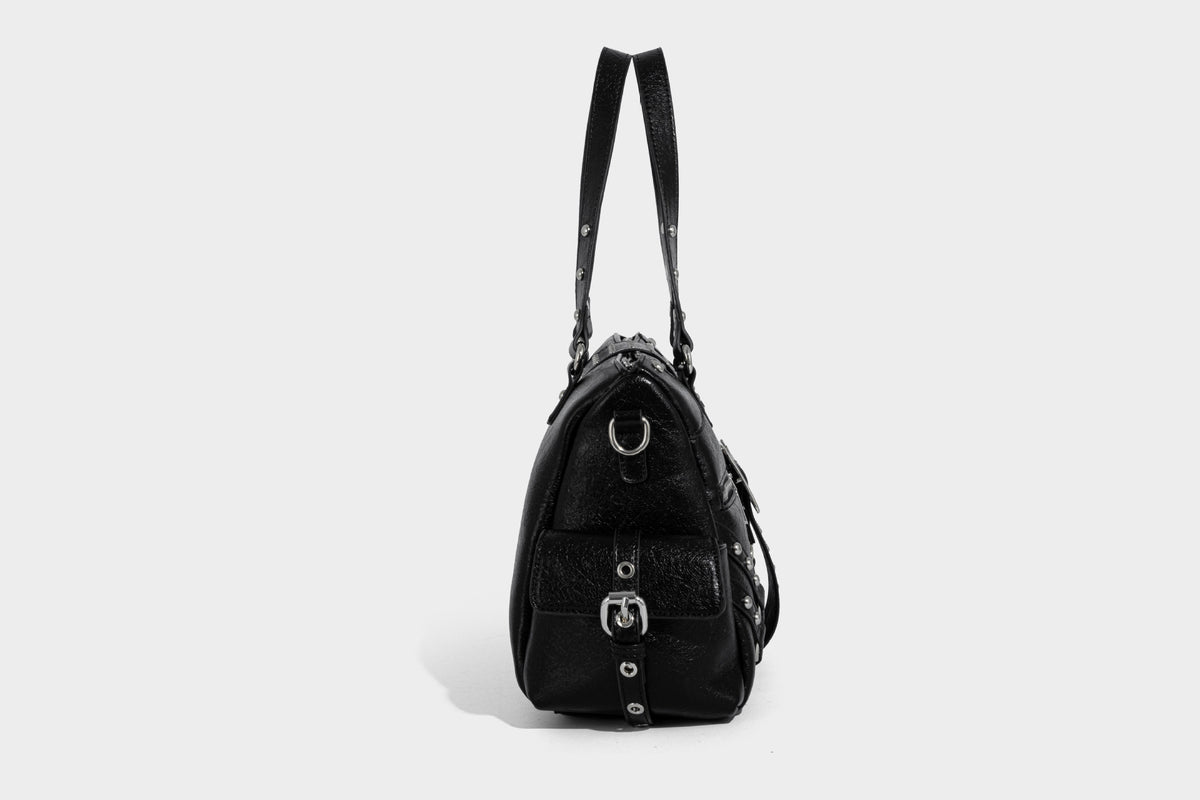 Schwarze, glänzende Henkeltasche mit genarbter Struktur, silberfarbenen Nieten, Riemendetail mit Schnalle, zwei Henkeln und breitem, mit Nieten besetztem Schulterriemen