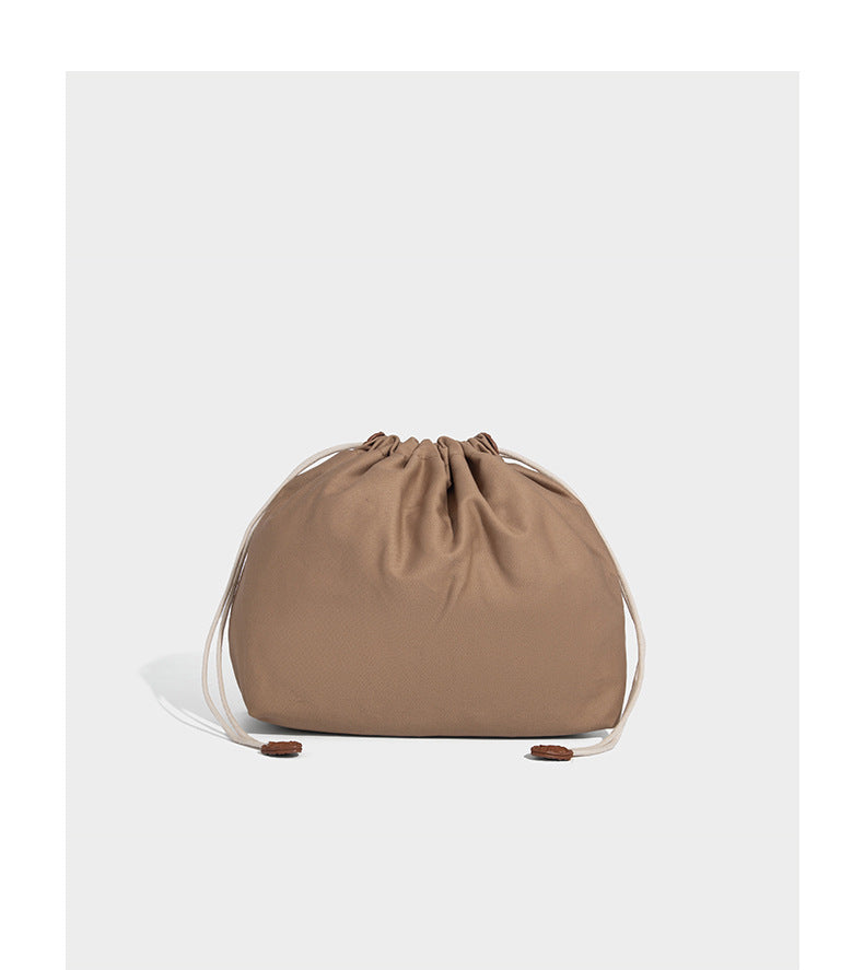 Large open-top woven tote bag with contrasting braided double handles and matching drawstring pouch, detail view 16