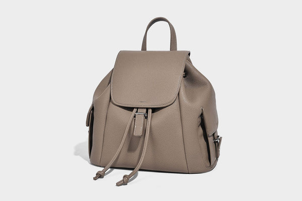 Compact pebbled leather-look flap drawstring backpack handbag with side pockets, top handle, and silver-tone hardware, detail