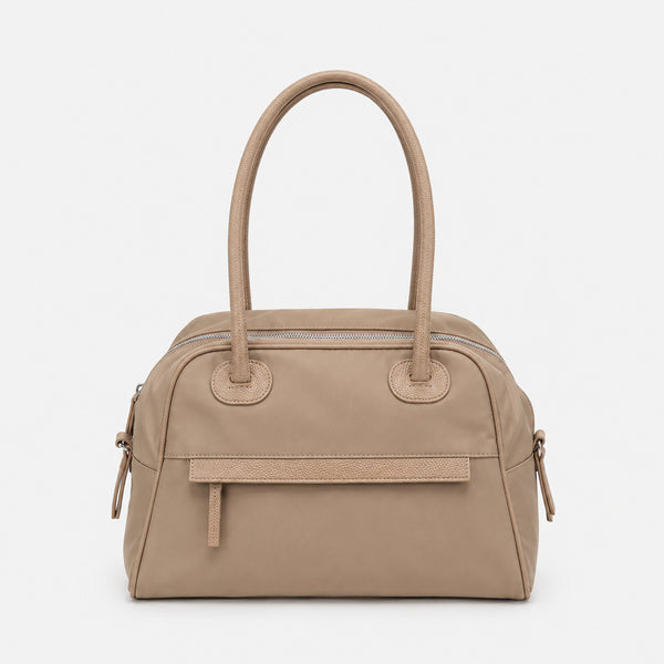 Structured dome top-handle bag in matte nylon with pebbled vegan leather-look trim, zip-top closure, front slip pocket, and