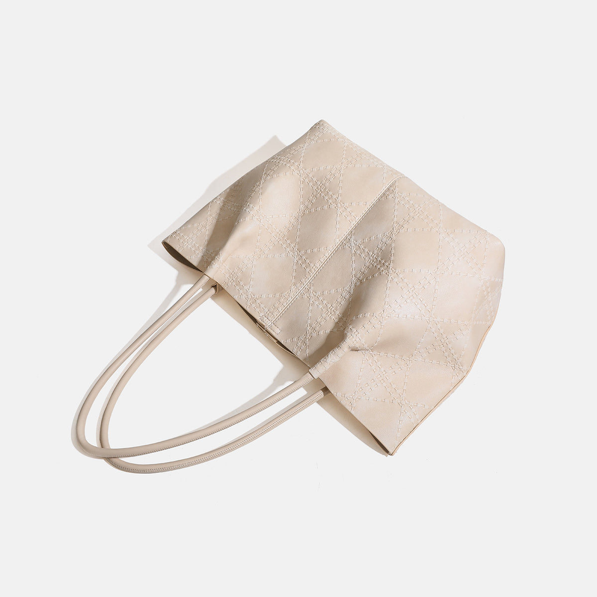 Large open-top tote bag with raised diamond-lattice stitching, long double shoulder handles, and gold-tone magnetic snap